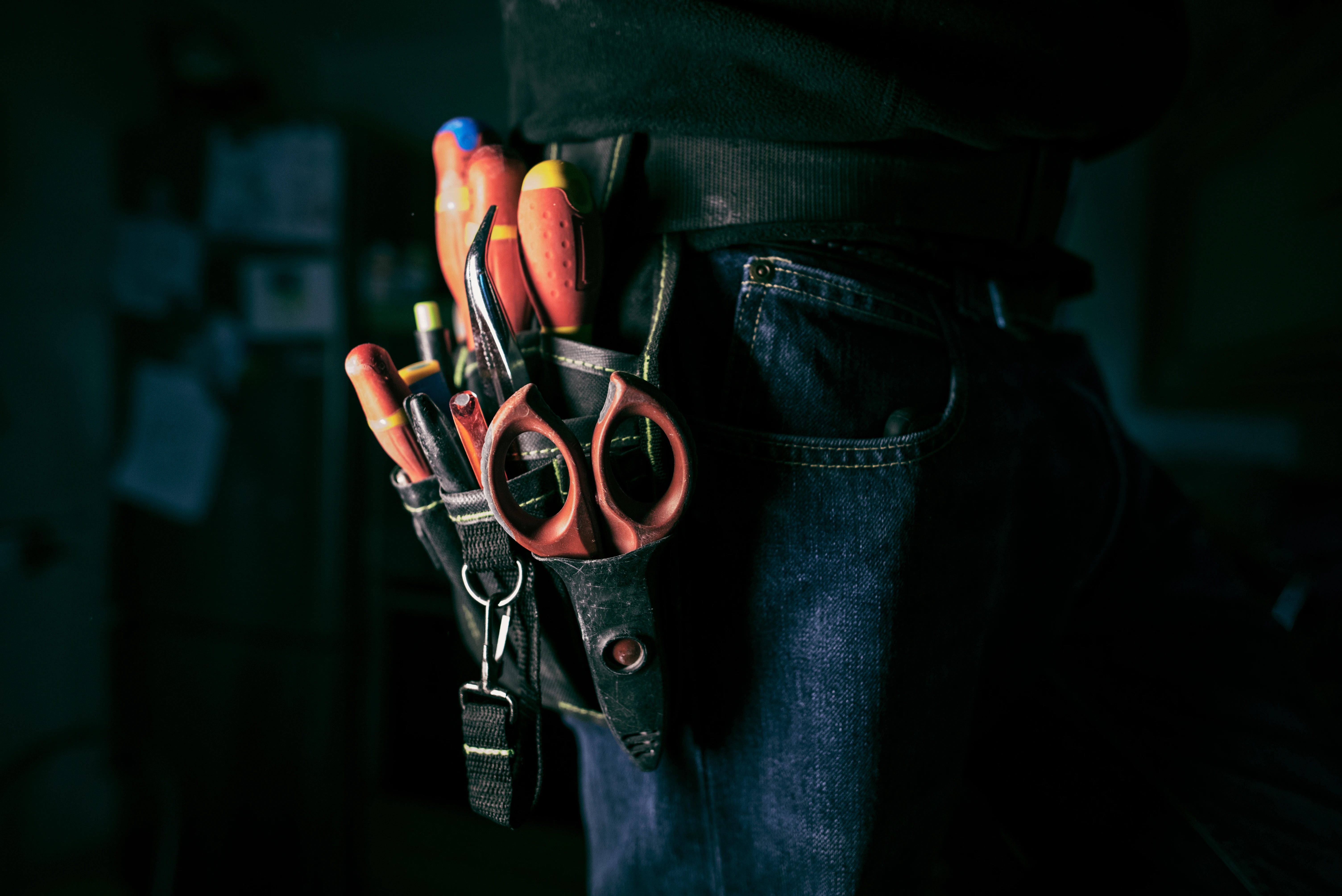 A person holding a pair of scissors in their pocket.
